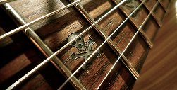 Guitar with skull and crossbones design on fret